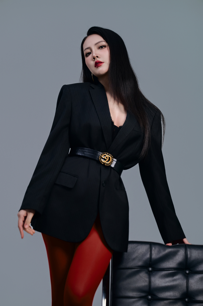 Bà mẹ hai con tự tin khoe vẻ gợi cảm khi váy dáng vest, để lộ nội y lấp ló. Sự phá cách, nổi loạn nằm ở kiểu trang điểm ấn tượng sắc sảo và quần tất màu đối lập với trang phục.