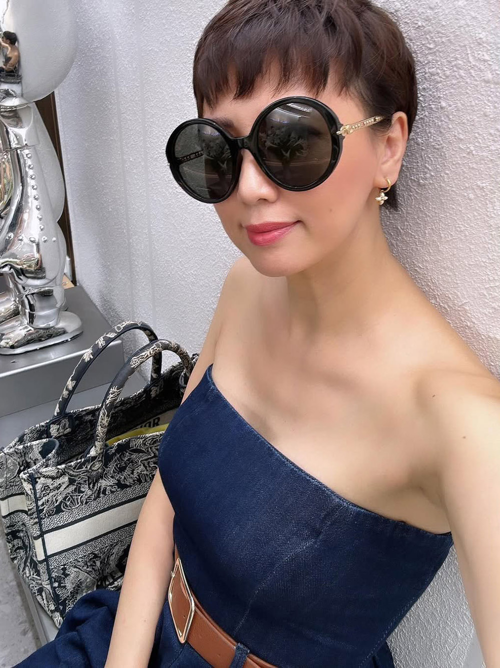 Jumpsuit chất liệu denim dáng quây không chỉ năng động mà còn giúp người đẹp 49 tuổi tôn vai trần. Bà tô điểm vẻ ngoài bằng kính râm Gucci và bông tai Louis Vuitton nhỏ xinh.