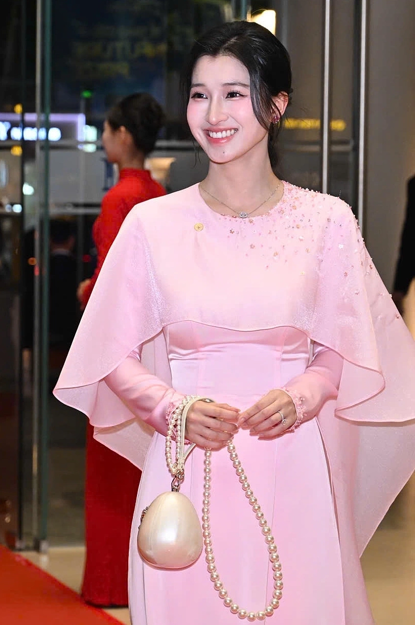 Á hậu diện áo dài, xách túi hình quả trứng khi dự một sự kiện cuối năm 2025. Sau cưới, người đẹp sẽ tập trung cho cuộc sống hôn nhân đồng thời hỗ trợ chồng kinh doanh. Hồi tháng 10/2025, cô được thông báo làm cổ đông tại công ty con của Vingroup, sở hữu 1% vốn. Ảnh: Giang Huy