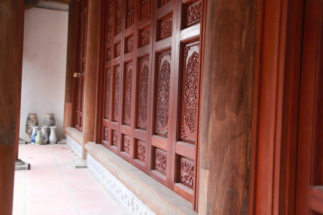 Hệ Thống Cửa Bức Bàn Được Phục Dựng Đúng Chất Liệu, Hoa Văn Truyền Thống. Màu Gỗ Trầm Ấm, Không Sơn Son Lòe Loẹt, Góp Phần Giữ Lại Vẻ Mộc Mạc, Tĩnh Tại Của Không Gian Thờ Tự.