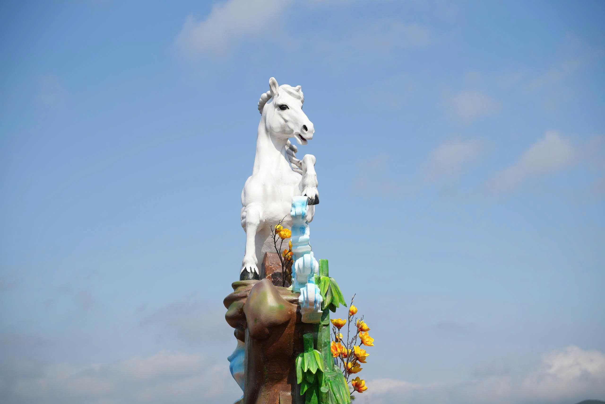 Theo đó, linh vật cao 3m, đế 1,2m được làm bằng xốp, tạo hình với sắc trắng tinh khôi, tượng trưng cho sự thuần khiết và quý phái. Tư thế ngựa đang tung vó trên những vách đá, mây ngàn và khóm tre xanh tạo nên một khung cảnh hùng vĩ.