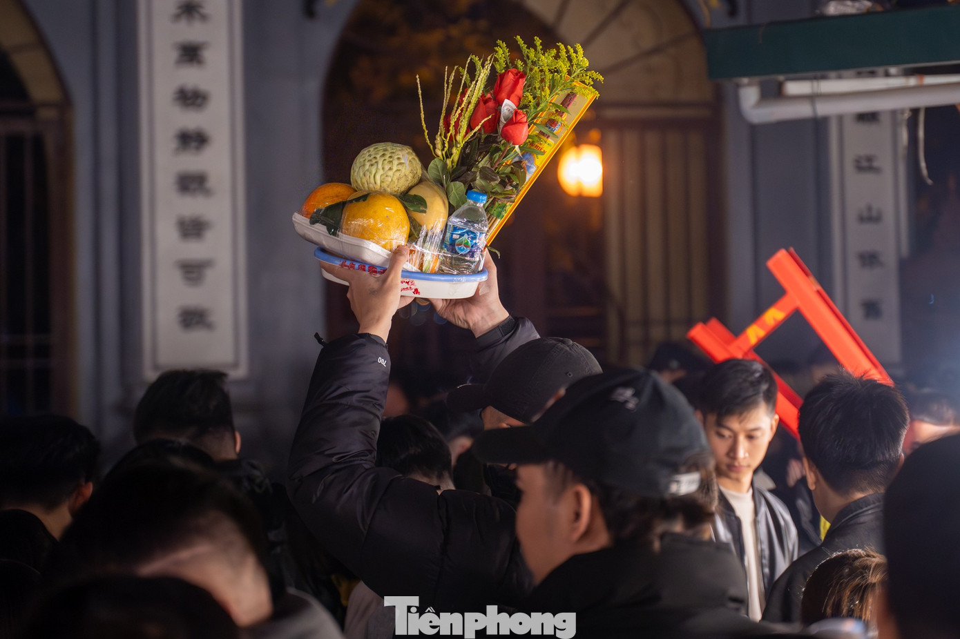 Do quá đông nên nhiều người phải bê lễ lên cao tránh va chạm.