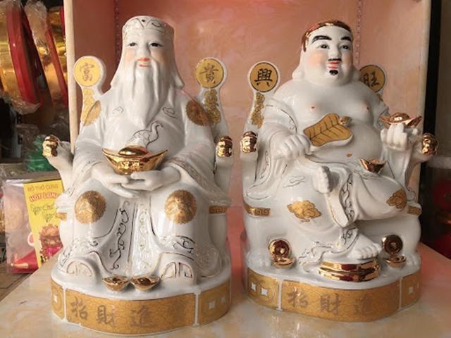 Vệ sinh sạch sẽ cho tượng Thần tài với nước bưởi và một chiếc khăn sạch.