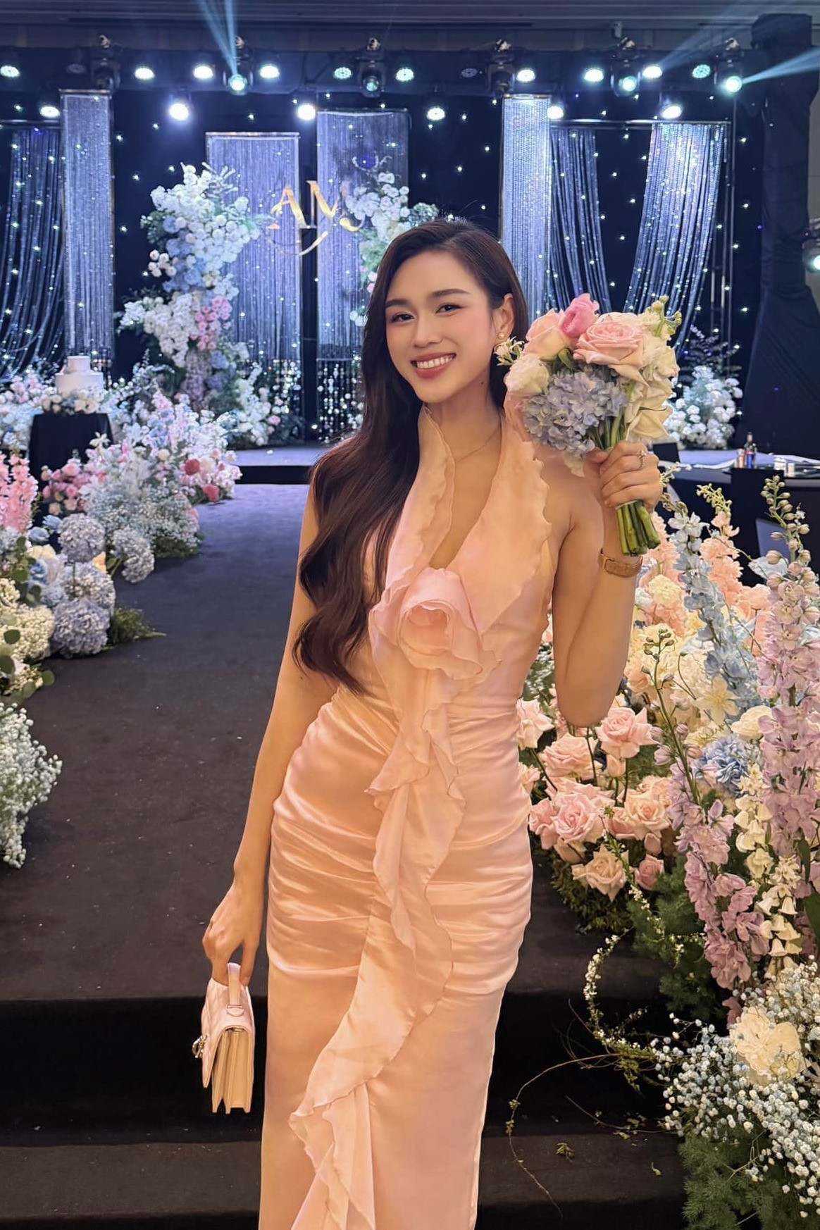 Cô diện đầm ôm, chi tiết bèo nhún tạo hình ảnh hoa hồng ở ngực tại một bữa tiệc.