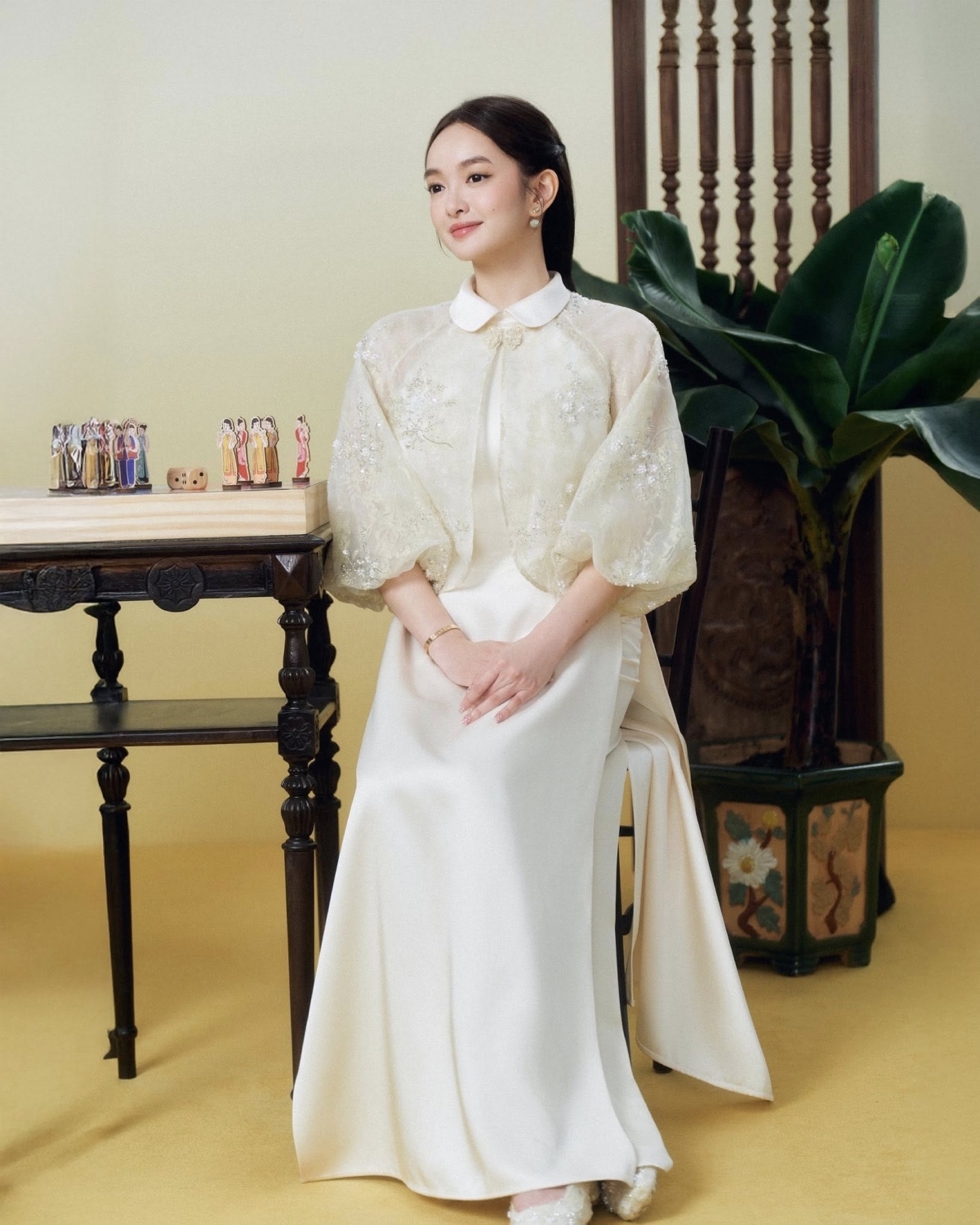 Kaity Nguyễn chọn áo dài kiểu tiểu thư với phần tay bồng, cổ sen, đính kết hoa. Thiết kế gợi cảm hứng cổ điển, phù hợp với những ai yêu vẻ đẹp dịu dàng, nữ tính.