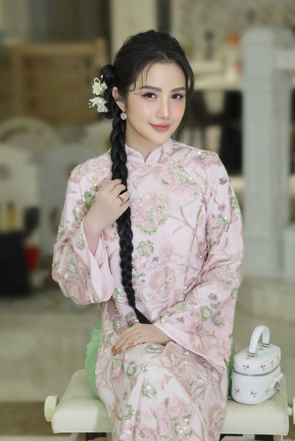 Cô tạo điểm nhấn trang phục với túi Dior da cừu trắng, họa tiết Cannage, thêu hình chim bồ câu và hoa hồng, thuộc BST Dioramour. Sản phẩm có giá khoảng 118 triệu đồng trên website của hãng.