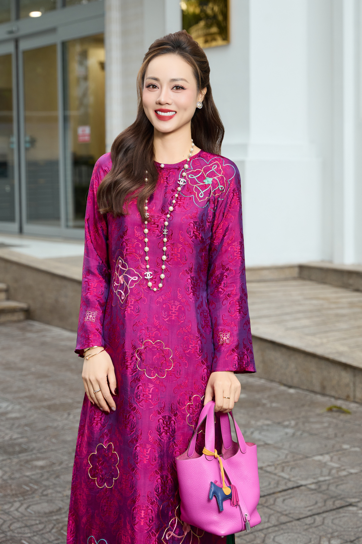 Cô kết hợp với túi xách Hermes Picontin đồng điệu tông màu và vòng cổ ngọc trai của Chanel để tăng phần sang trọng.