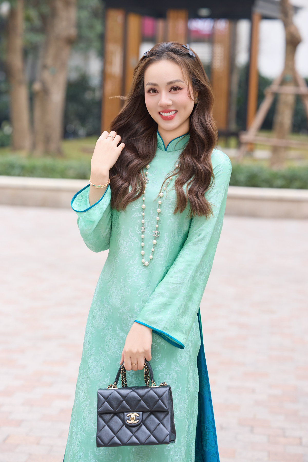 Với mẫu áo dài tông xanh ngọc, Ngọc Hà chọn chiếc túi Chanel giá khoảng gần 200 triệu đồng.