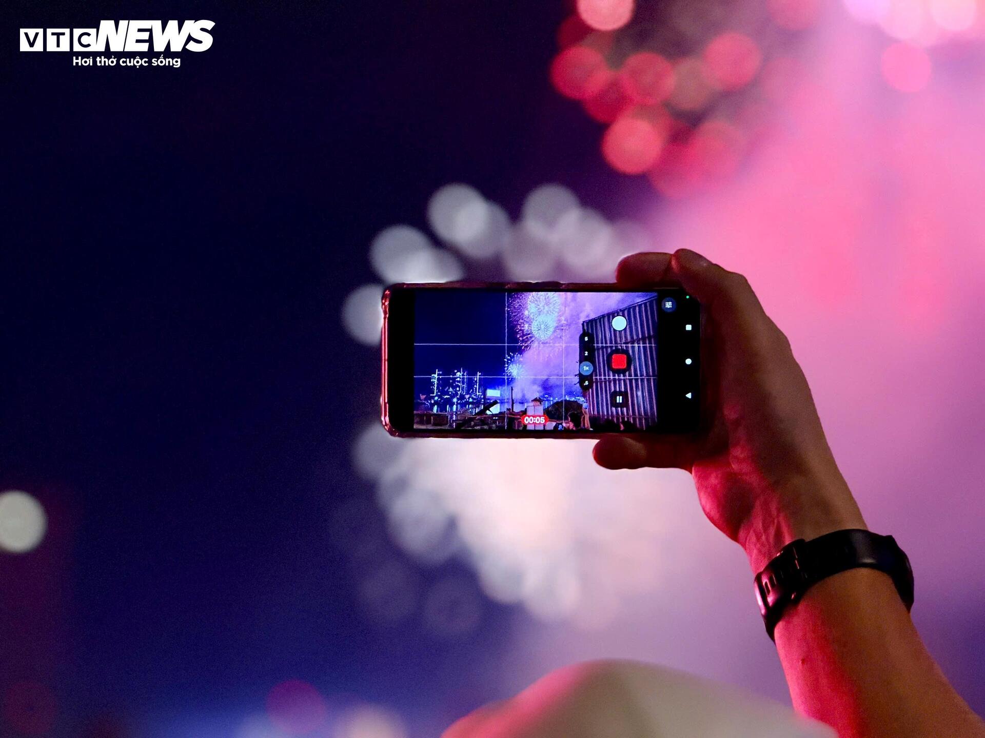 Nhiều người tranh thủ ghi lại hình ảnh ấn tượng bằng điện thoại, lưu giữ thời khắc mở đầu cho một năm mới an lành.