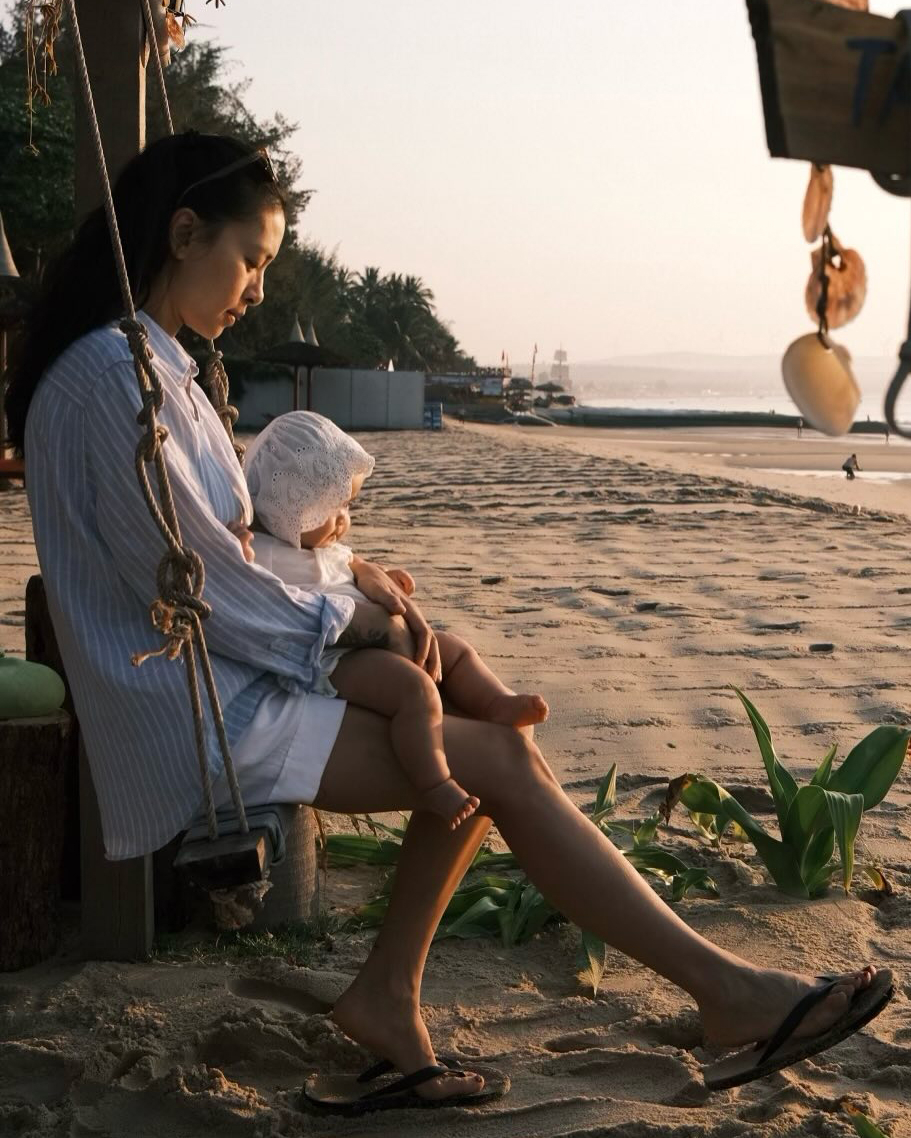 Trong chuyến đi biển cùng chồng và con gái hồi đầu năm, mẹ bỉm sữa diện sơ mi rộng thoải mái, hạn chế tối đa cách mix-match cầu kỳ.