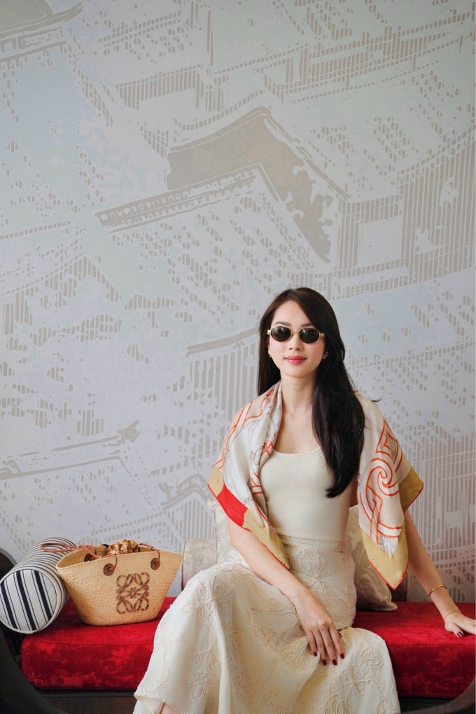 Bà mẹ ba con trung thành với phong cách nền nã, dịu dàng khi phối áo tank-top với chân váy màu be cùng tông. Chiếc khăn lụa của nhà mốt Hermes cùng túi cói Loewe trở thành điểm nhấn cho bộ trang phục đi biển. Cô hoàn thiện phong cách bằng kính râm gọng mạ vàng cùng khuyên tai Dior.