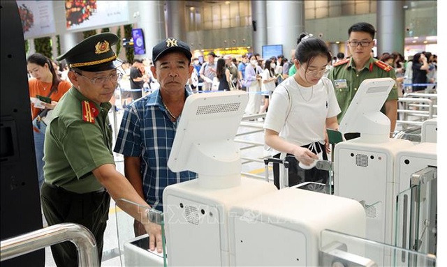 Hướng dẫn hành khách sử dụng hệ thống Cổng kiểm soát tự động tại cổng nhập cảnh. Ảnh: TTXVN