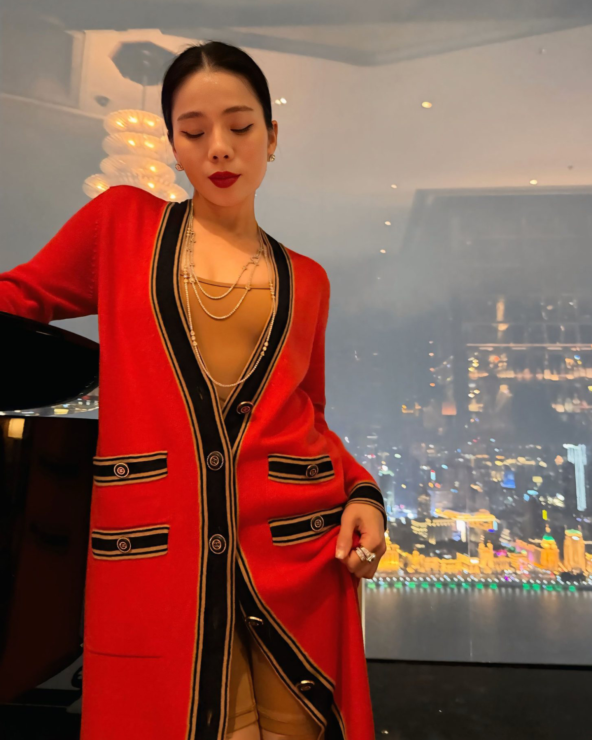 Lệ Quyên lên đồ nổi bật trong chuyến du xuân cùng bạn trai. Nữ ca sĩ phối hai màu đỏ - be với cardigan Chanel bên ngoài bodysuit ôm sát.