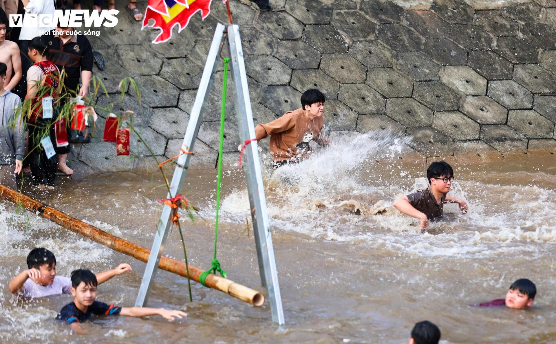 Ở khu vực giữa dòng, một nhóm bạn trẻ liên tục lặn xuống rồi nổi lên trong tiếng hò reo.