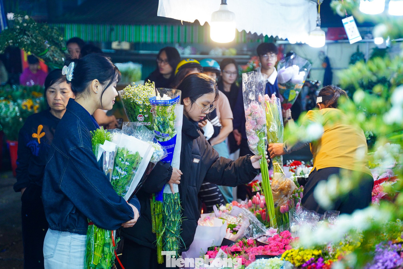 Bạn Chu Thủy (áo đen, đang lựa hoa) chia sẻ: “Tôi và bạn thân mang khoảng 2 triệu đồng đến chợ nhập hoa về bán thử. Hai đứa dự định bày bán ở khu vực vỉa hè quanh hồ Tây, hy vọng kiếm thêm chút tiền và có thêm trải nghiệm kinh doanh”.
