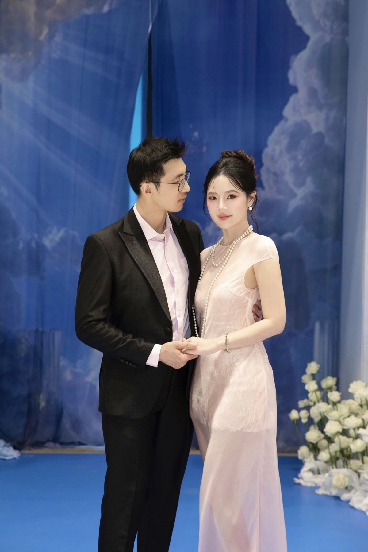 Trong khi Midu diện đầm phối voan xuyên thấu tông hồng pastel để tôn da trắng, Minh Đạt khéo chọn chiếc sơ mi hồng nhạt ăn nhập cùng trang phục của vợ. Bộ đồ giúp họ được khen trông thanh lịch.