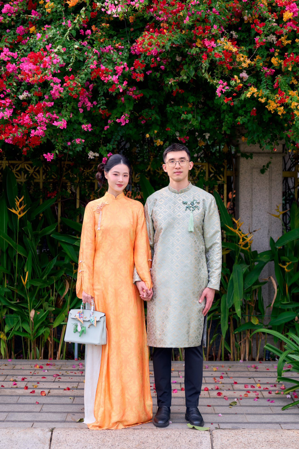 Dịp Tết vừa qua, Midu và Minh Đạt khoe ảnh tay trong tay cùng áo dài đôi. Thiếu gia nhà nhựa Duy Tân khéo chọn chiếc áo dài có màu sắc tương đồng với chiếc túi xách Hermes của vợ.