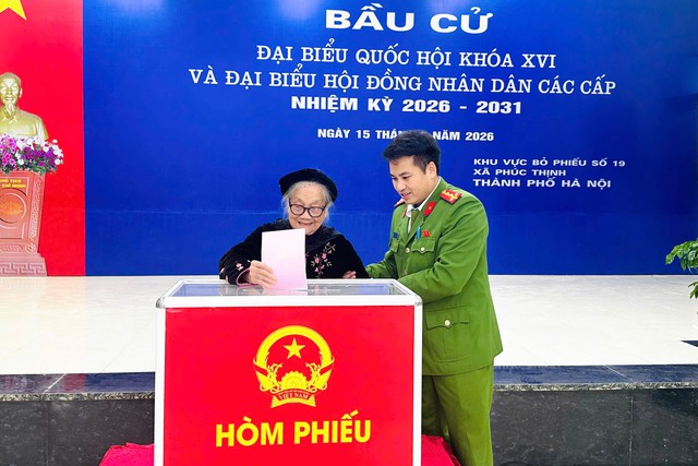 Lực lượng chức năng hỗ trợ cử tri tại điểm bỏ phiếu xã Phúc Thịnh, TP Hà Nội sáng 15/3.