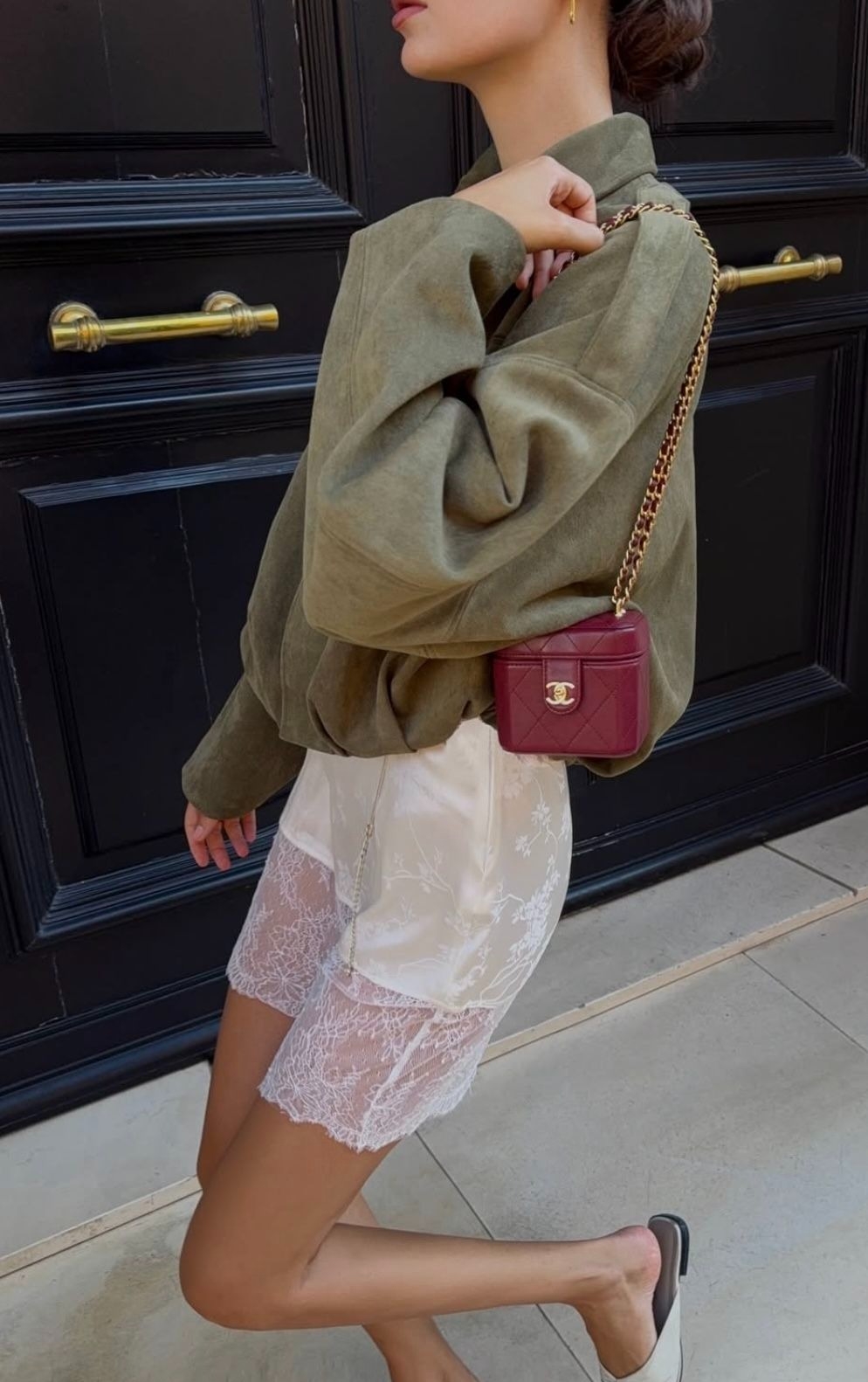 Một cô gái phối quần ren cùng sweatshirt và túi Chanel, tạo nên vẻ ngoài thanh lịch và phóng khoáng.