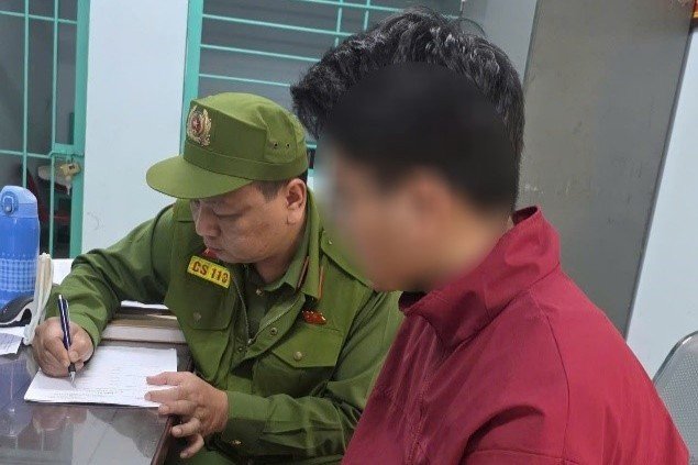 Nam thanh niên H (áo đỏ) làm việc với cảnh sát.