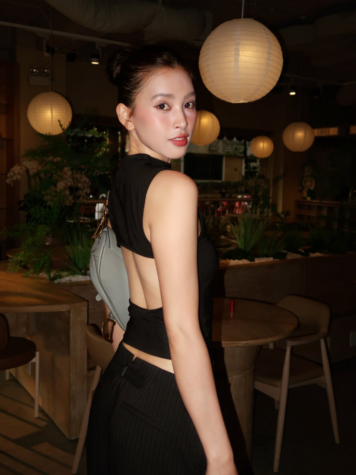 Chi tiết cut-out sau áo giúp hoa hậu Tiểu Vy khoe rãnh lưng và bộ trang phục đen bớt đơn điệu.