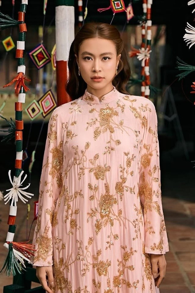 Hoàng Thùy Linh đầy sang trọng trong thiết kế áo dài suông đính kim sa vàng ánh kim lấp lánh. 