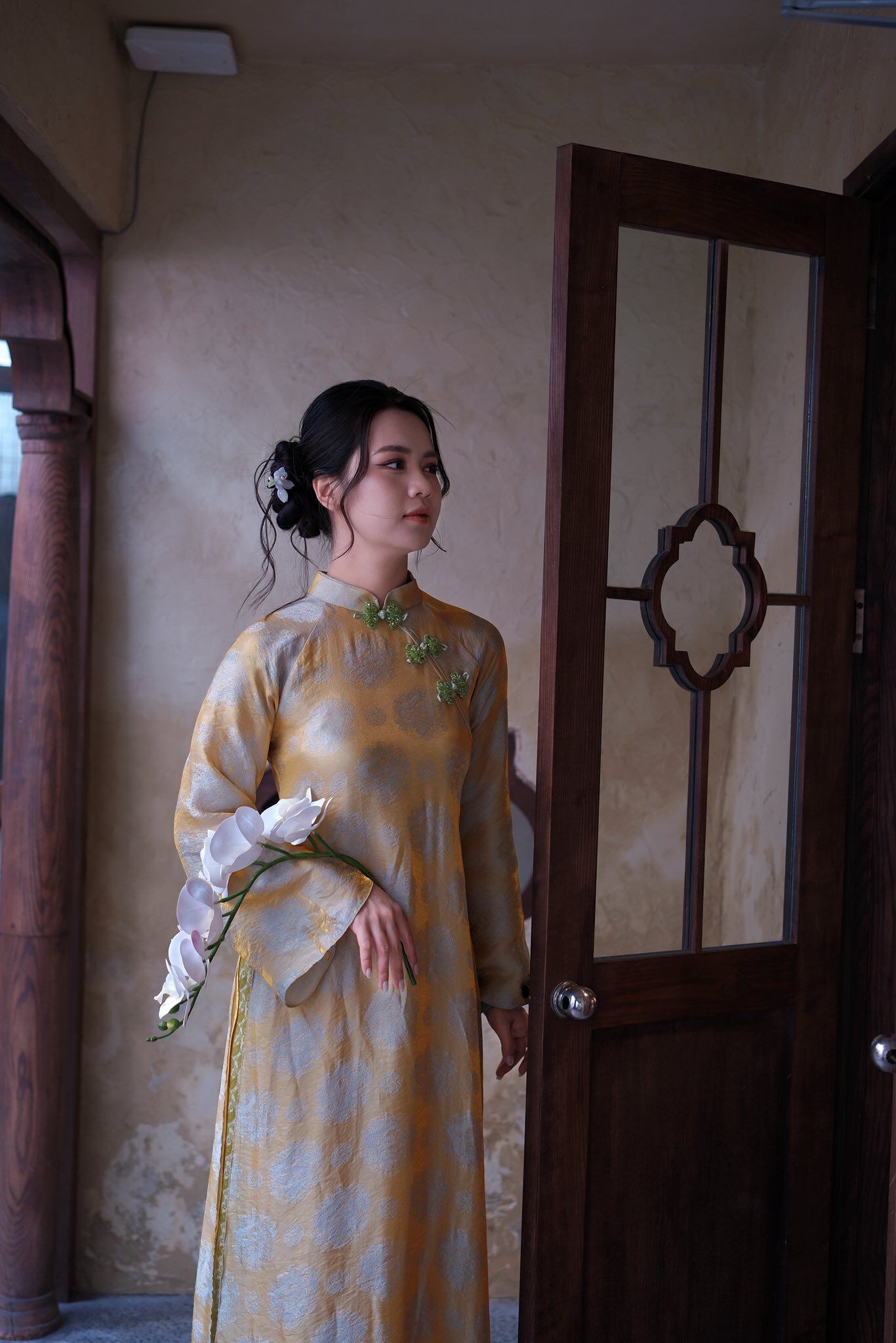 Trong loạt ảnh diện áo dài Tết, bà xã Quế Ngọc Hải chọn thiết kế vàng – be nhã nhặn, phom cổ điển tôn nét Á Đông. Tóc búi thấp, makeup trong veo càng làm nổi bật vẻ ngọt ngào, đằm thắm nhưng vẫn đầy cuốn hút.