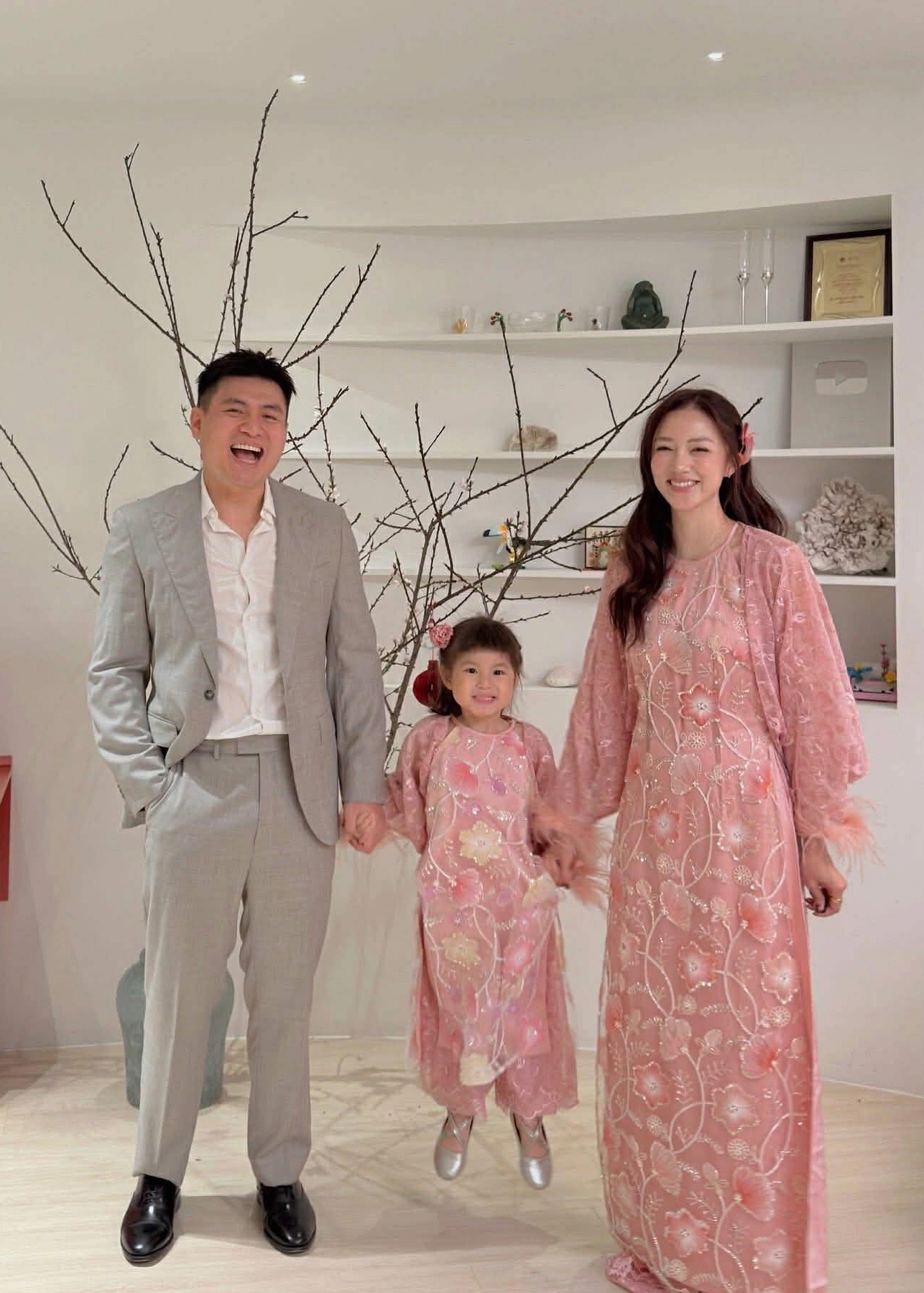 Nàng dâu tập đoàn may mặc Salim gây chú ý khi cùng con gái – bé Pam – diện áo dài ren kim sa đính lông vũ, thiết kế đang “làm mưa làm gió” mùa Tết năm nay. Chất liệu ren xuyên thấu phủ kim sa lấp lánh kết hợp chi tiết lông vũ mềm mại ở tay áo và tà áo mang đến hiệu ứng bay bổng, sang chảnh nhưng vẫn giữ được nét duyên dáng truyền thống.