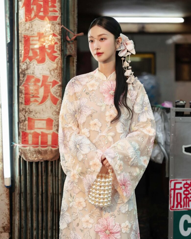 Jun Vũ diện thiết kế áo dài đính hoa nổi 3D vô cùng nổi bật. Phom dáng ôm vừa vặn tôn vóc dáng thanh thoát, trong khi chất liệu xuyên thấu tinh tế giúp tổng thể vừa mong manh vừa hiện đại. 