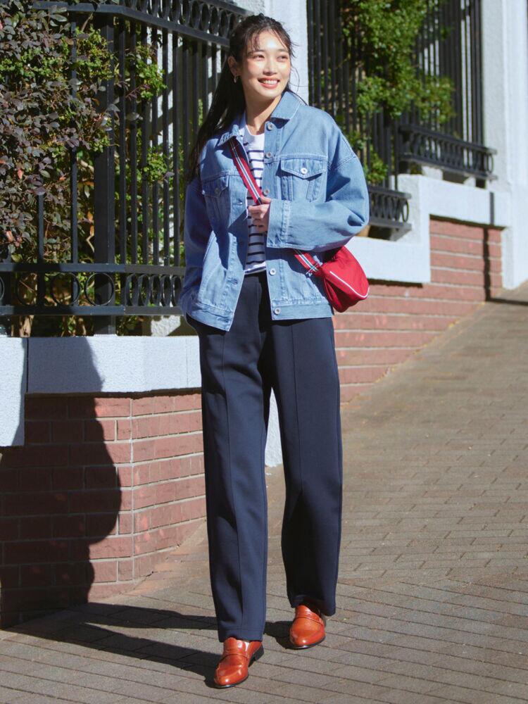 Áo khoác denim xanh nhạt đi cùng quần âu xanh navy tạo nên sự chuyển tông mượt mà. Chiếc túi đỏ phá vỡ sự an toàn của bảng màu lạnh. Sự tương phản xanh - đỏ giúp set đồ công sở trở nên trẻ trung, linh hoạt mà vẫn giữ được nét chỉn chu.