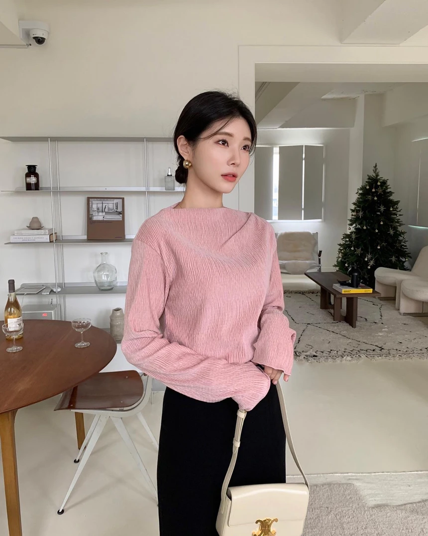 Áo len hồng phấn đi cùng chân váy đen dài là công thức tương phản đầy hiệu quả. Sắc hồng làm dịu đi sự nghiêm túc của màu đen, trong khi đen lại giúp hồng trở nên trưởng thành hơn. Túi trắng kem hoàn thiện bảng màu theo hướng tối giản, hiện đại.