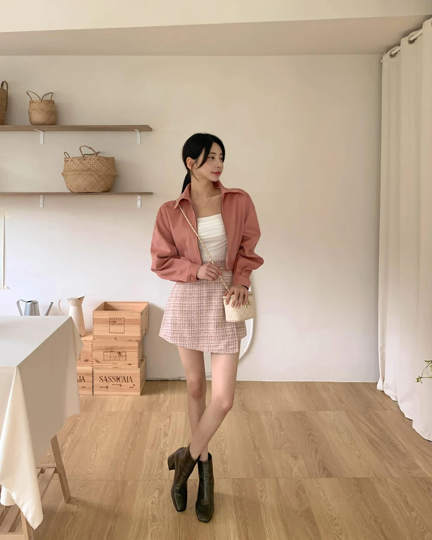 Áo sơ mi hồng đất phối cùng chân váy tweed hồng nhạt tạo hiệu ứng layering sắc độ tinh tế. Bên trong là áo trắng kem trung hòa tổng thể, giúp bộ đồ không quá “ngọt”. Sự kết hợp này mang lại hình ảnh nữ tính, mềm mại nhưng vẫn đủ thanh lịch cho môi trường công sở sáng tạo.