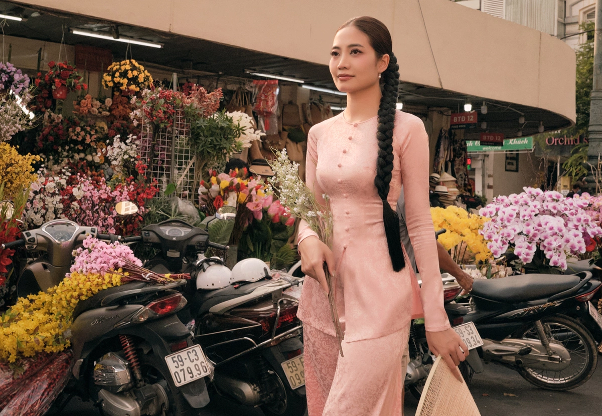 Thiết kế áo bà ba dáng ôm vừa vặn, chất liệu lụa trơn màu hồng phấn nhẹ nhàng, nổi bật với hàng nút vải chạy dọc thân áo phù hợp với chị em nào có dáng người đẹp. Phom áo tôn dáng nhưng không gò bó, kết hợp cùng quần lụa đồng màu tạo nên tổng thể mềm mại, nữ tính. 