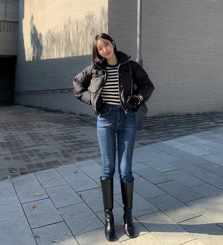 Set đồ theo quy tắc “trên rộng, dưới hẹp” với áo phao dáng phồng tạo độ bồng bềnh cho phần thân trên. Phía dưới, quần jeans dáng ôm kết hợp boots cao cổ giúp phần chân trông gọn gàng, cân bằng hoàn hảo với phần áo oversized.