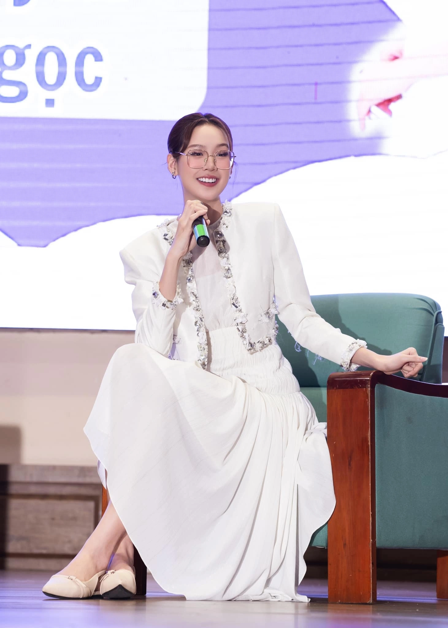 Áo khoác vải tweed trắng điểm chi tiết đính kết tinh xảo toát lên vẻ thanh lịch chuẩn mực cho những sự kiện hay hội thảo công việc. Hoa hậu Bảo Ngọc phối cùng váy liền đồng màu giúp tổng thể thêm phần duyên dáng, hiện đại.