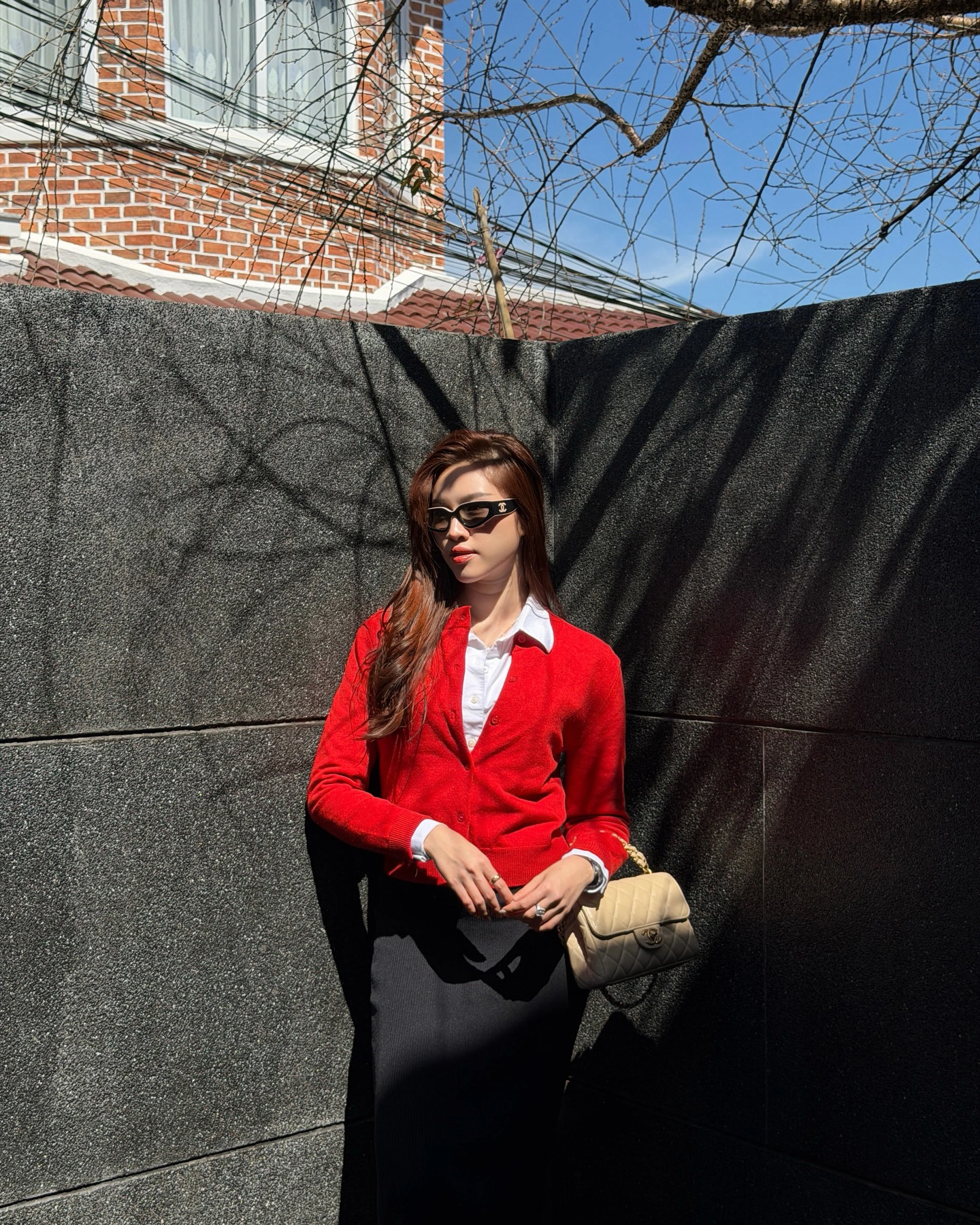 Đầu năm đi làm, còn gì đẹp hơn khi diện chiếc áo cardigan đỏ rực mang màu sắc may mắn được buông thả tự nhiên giúp che khéo vòng 2. Nữ MC Thanh Thanh Huyền tinh tế khi phối cùng sơ mi trắng tạo nên các lớp layer thời trang. Phía dưới, cô chọn chân váy đen dáng suông đơn giản mà thanh lịch.