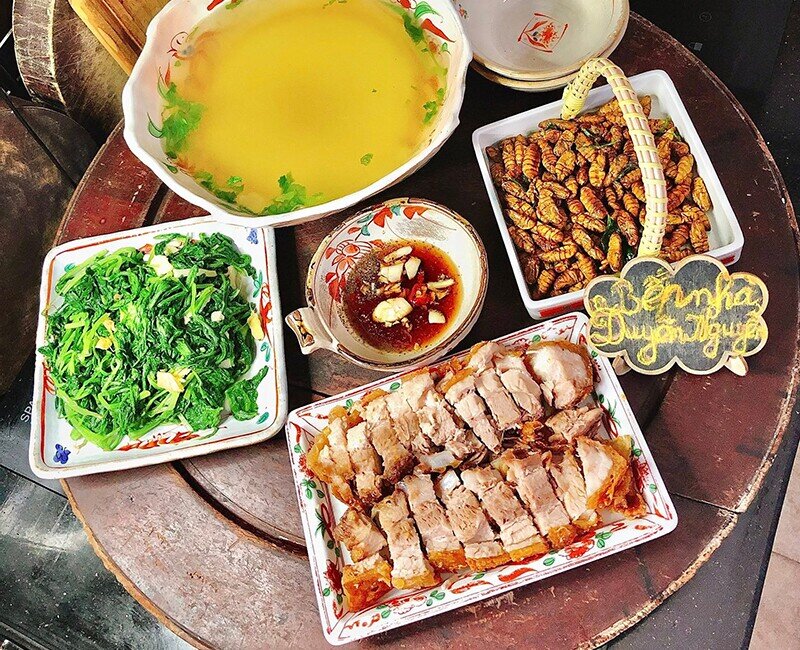 Mâm cơm này gồm các món: - Thịt quay giòn bì - Nhộng rang lá chanh - Rau cải xào gừng tỏi - Canh rau cải luộc (Ảnh: Thùy Duyên)