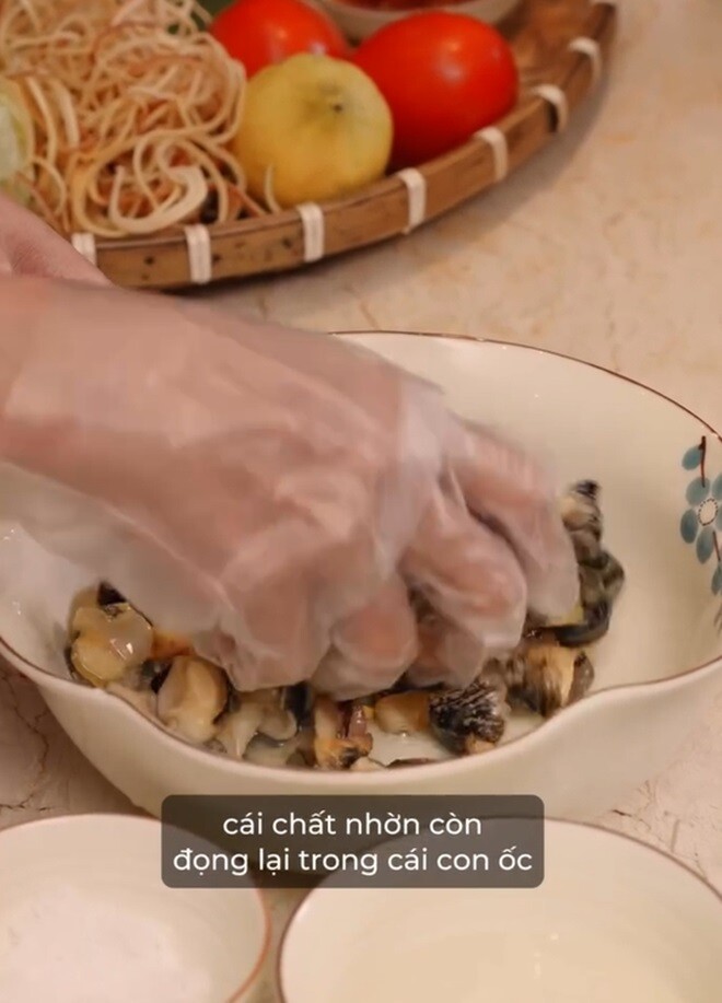 Làm sạch ốc rồi, cô còn rửa lại một lần nữa với một ít giấm và muối, bóp để cho ra hết những chất nhờn trong con ốc rồi rửa lại bằng nước.