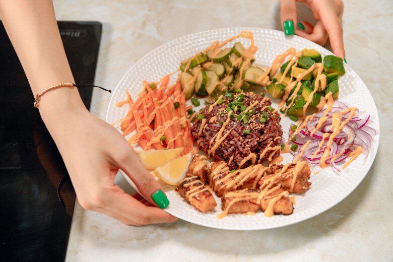 Từng chi tiết nhỏ đều được cô chăm chút kỹ lưỡng. Đĩa cơm gạo lứt cá hồi hoàn chỉnh với đầy đủ các nhóm chất: tinh bột tốt, đạm và thật nhiều rau củ tươi. Một khẩu phần ăn chuẩn chỉnh cho việc giữ dáng.