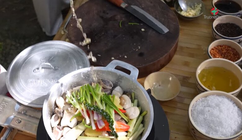 Cận cảnh nồi nghêu đầy ắp sả, gừng, ớt và tiêu xanh chuẩn bị lên bếp. Trường Giang rưới bia vào nồi để làm món nghêu xông hơi thơm nồng.