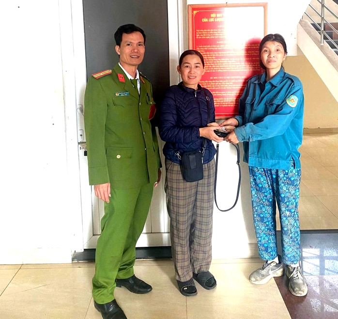 Chị Trần Thị Hoa Lý (bên phải) trao trả chiếc túi xách cho người đánh rơi. Ảnh: Công an Vĩnh Linh