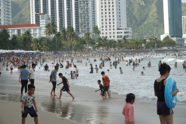 Người dân, du khách đến bãi biển Nha Trang vui chơi, tắm biển trong dịp Tết.