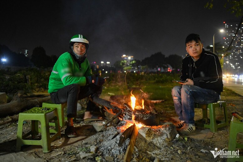 Tài xế xe ôm Hà Quốc Lâm thường đi làm từ 22h đến 7h hôm sau dù thời tiết khắc nghiệt. Đêm 6/1, anh tới một quán nước ven đường Phạm Hùng ngồi sưởi ấm trong khi chờ khách. 