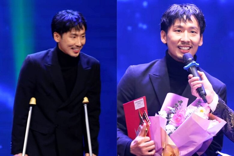 Tuấn Trần chống nạng lên sân khấu.