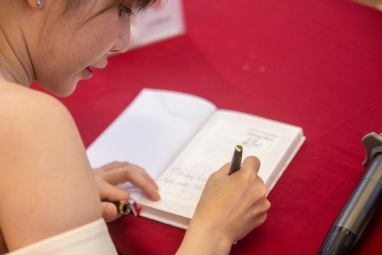 Tú Uyên ký tặng độc giả tại sự kiện.