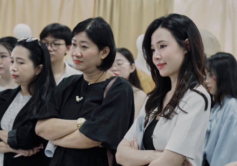 Midu chăm chú xem xét từng tác phẩm của sinh viên.