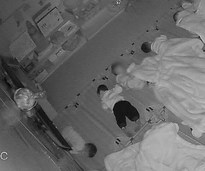 2 đứa trẻ không được đắp chăn trong khi những bạn cùng lớp đều có chăn để đắp.