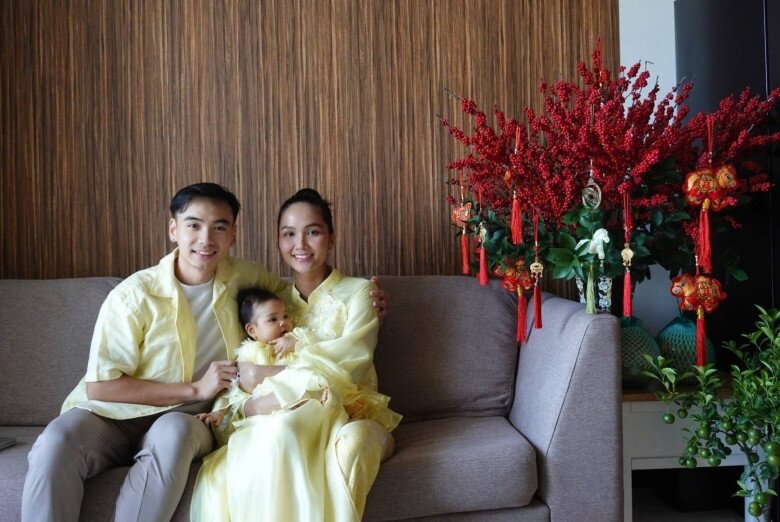 Cô nhóc được bố mẹ diện một chiếc áo dài màu vàng xinh xắn, nổi bật, chụp ảnh trong nhà.