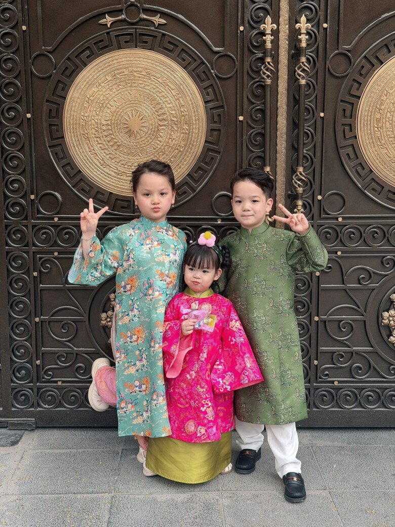 Nhóc tỳ được mẹ diện cho một bộ áo dài màu hồng xinh xắn, chụp ảnh cùng các anh chị em trong gia đình.