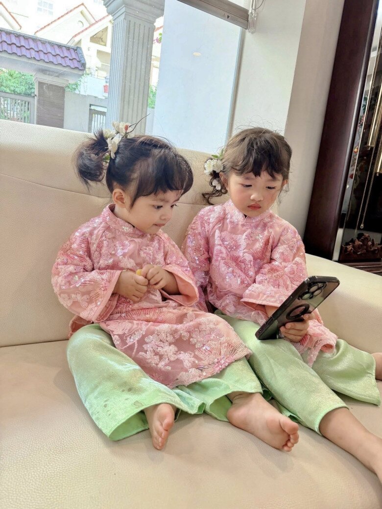 Winnie và Hannie mặc áo dài hồng nổi bật cùng bố mẹ đi chúc Tết.